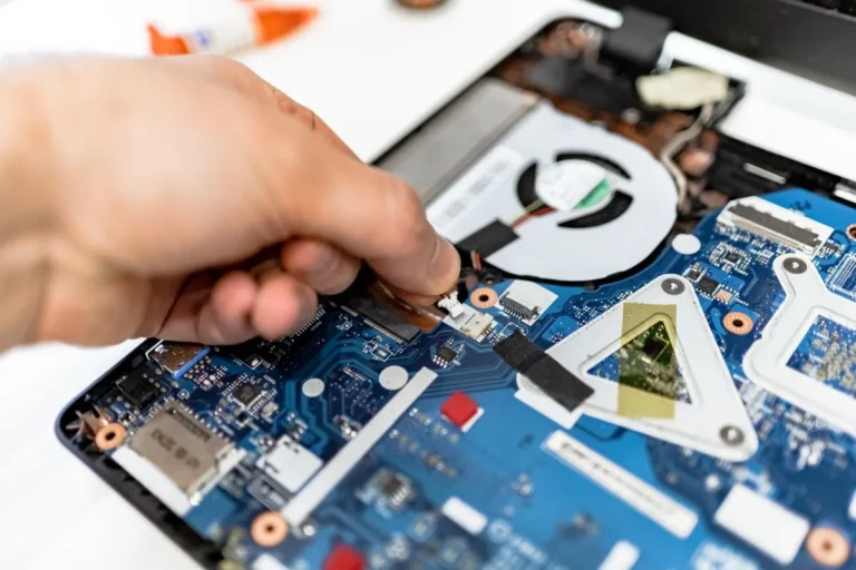 Técnico retirando la batería interna de una laptop abierta