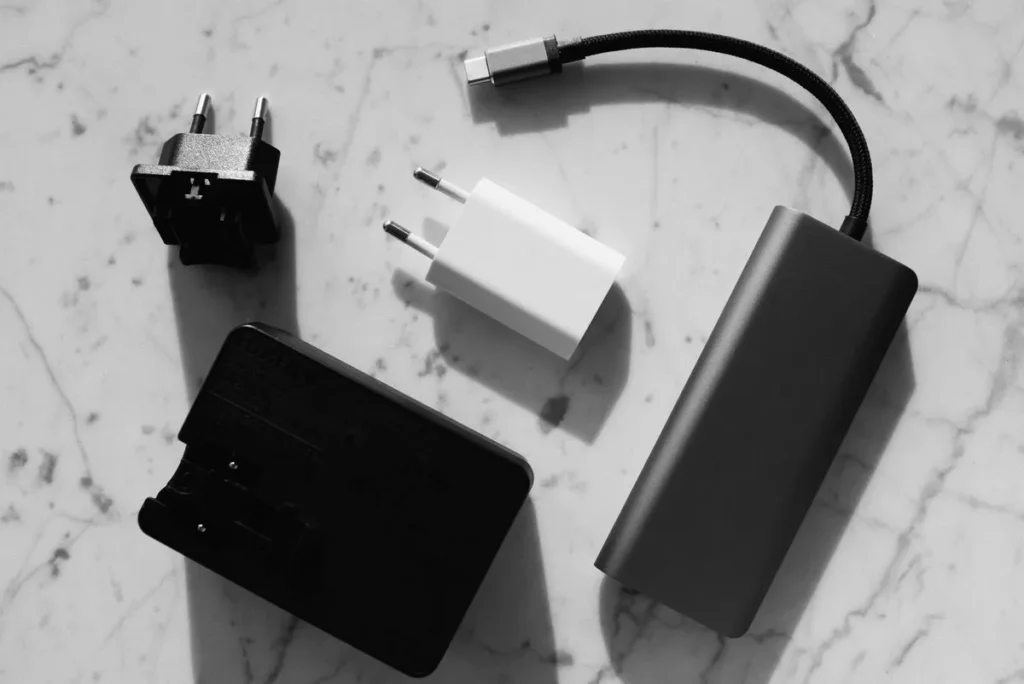 Cargador de laptop con su cable y conector sobre un escritorio