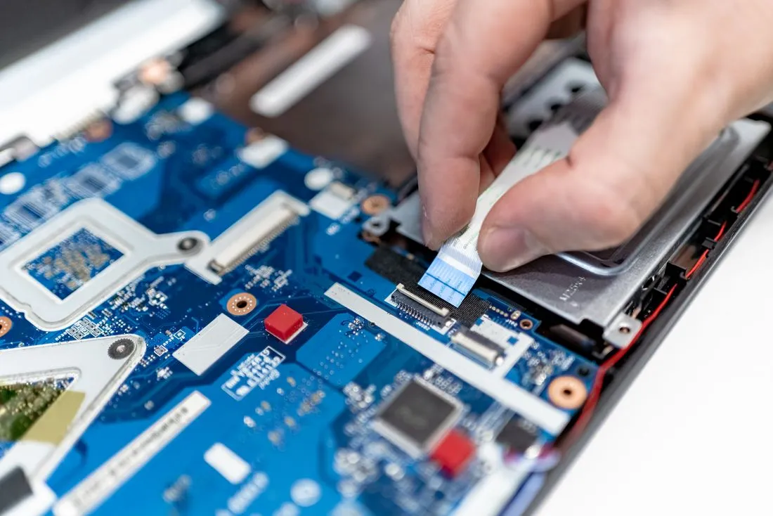 Técnico revisando una laptop en su mesa de trabajo