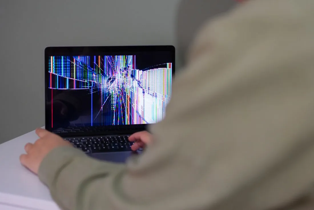 Manos de un técnico cambiando la pantalla de una laptop