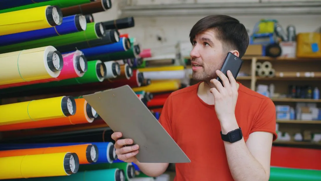 Dueño de una tienda revisando un pedido en su celular