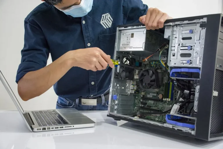 Técnico revisando el ventilador de una laptop abierta
